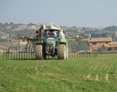 Jove agricultor treballant el camp amb màquina de llaurar